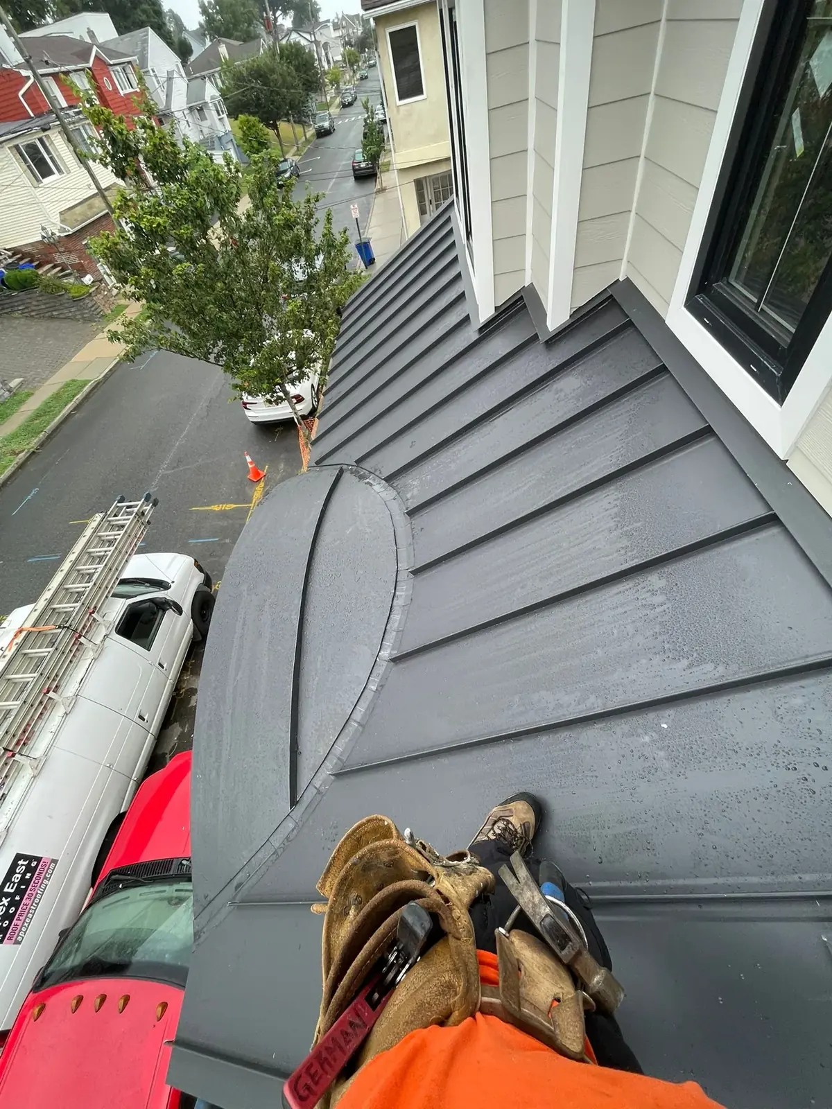 Close view of finished dark vertical panel siding with a curved trim detail