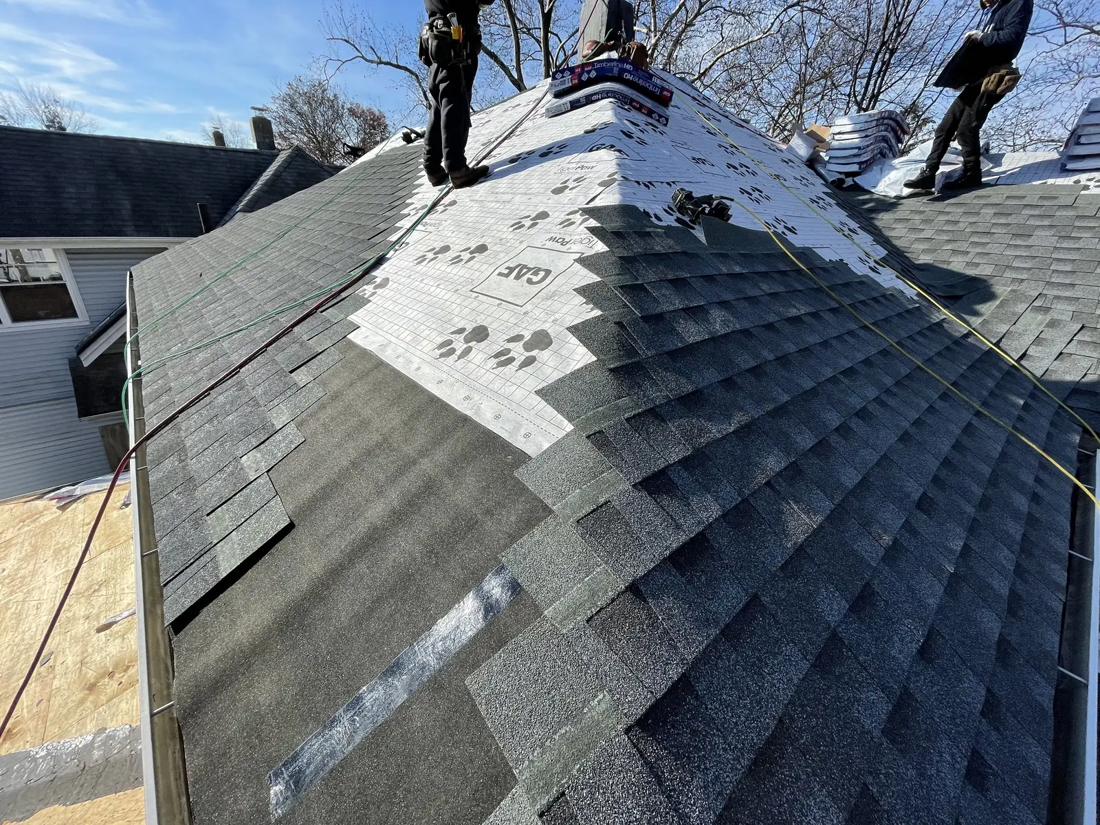 A Skyline Construction Group crew shingling a hip roof
