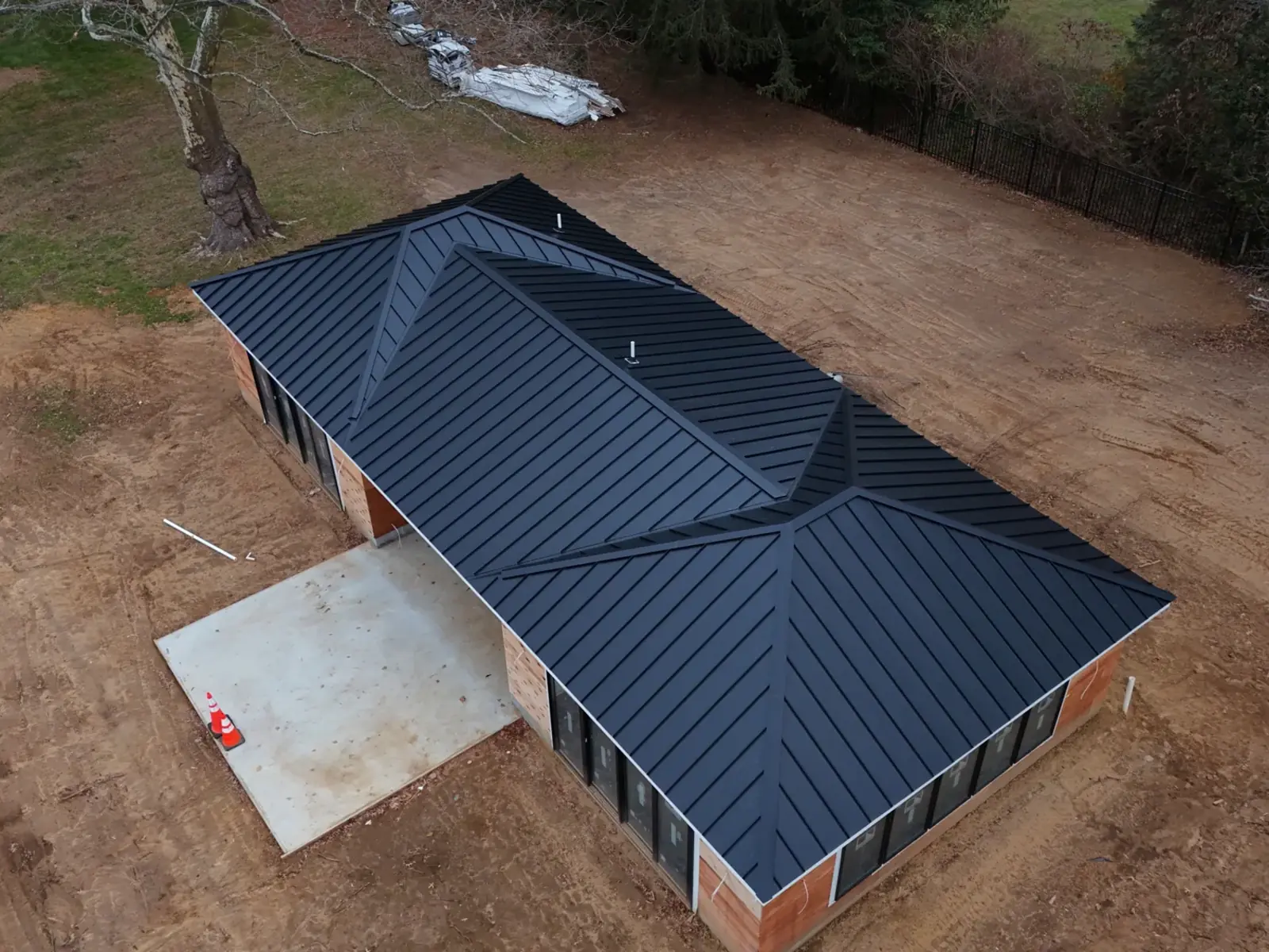 A finished black standing seam metal roof on a new residential build