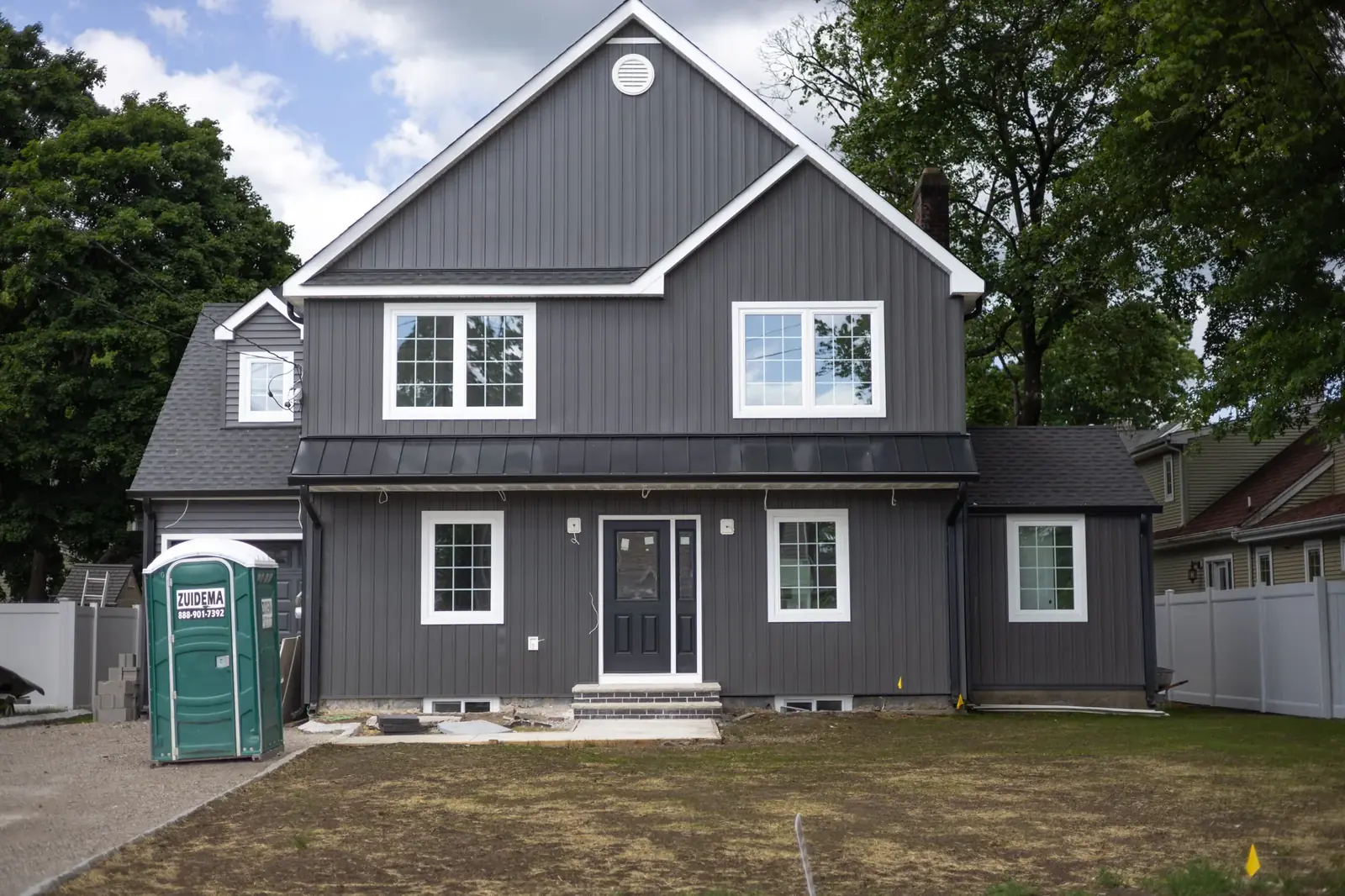 A finished dark board and batten farmhouse style home, front elevation