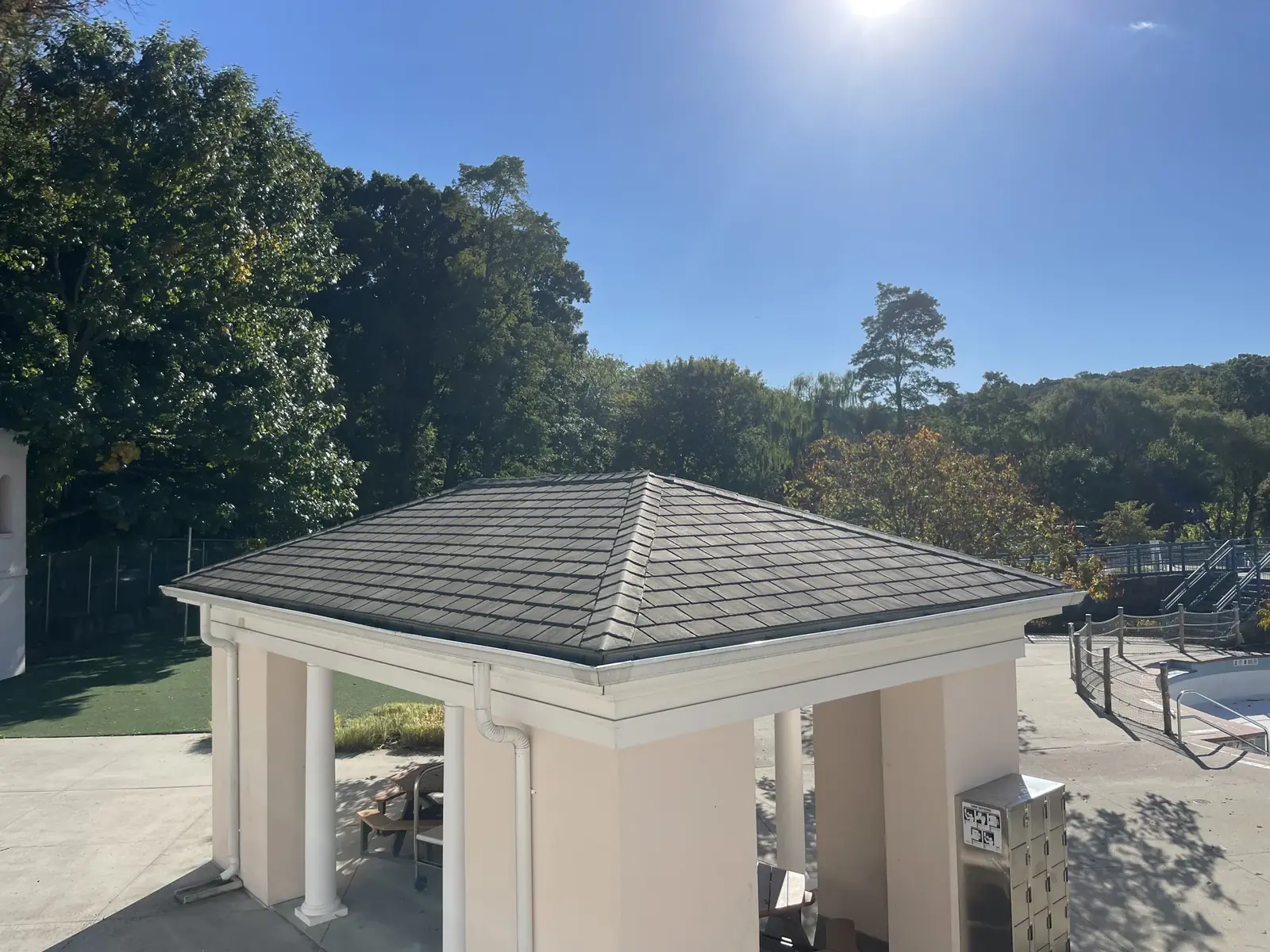 A finished hip shingle roof over a poolside pavilion