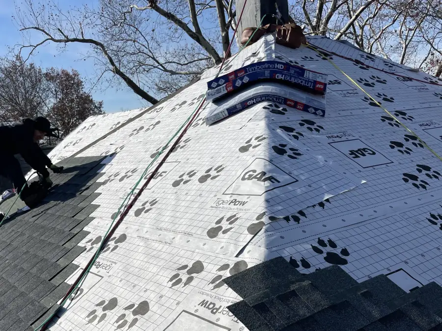 Crew working a ridge, roofing by Skyline Construction Group